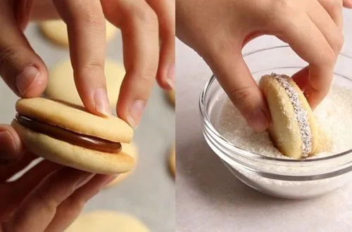 Una mano cubriendo cuidadosamente una tapa de maicena con manjar blanco para formar el alfajor.