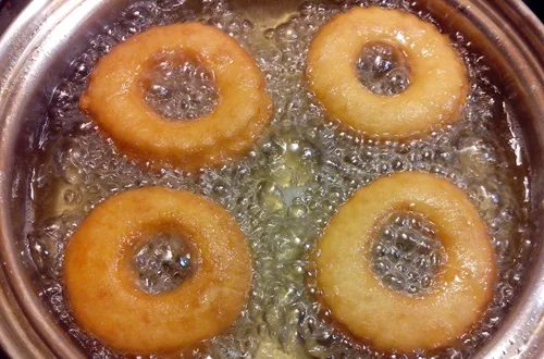Roscas friéndose Roscas sumergidas en aceite caliente burbujeante hasta alcanzar un tono dorado perfecto.