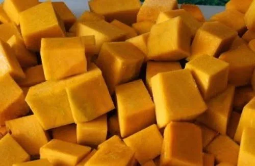 Zapallo amarillo picado Zapallo (calabaza) amarillo picado en cubos, ingrediente clave en la preparación de los porotos quebrados