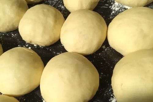 Masa de berlines Bollos de berlines chilenos listos para freir, espolvoreados con harina