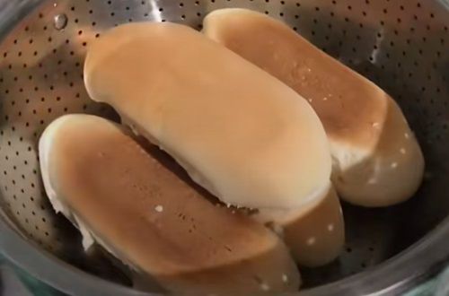 Panes tipo copihue calientándose a baño maría en una olla, un paso clave para los completos mojados.