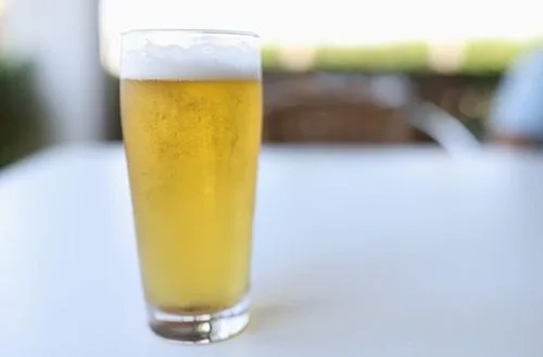 Cerveza Un vaso de cerveza lager rubia con espuma blanca, base fundamental del cóctel yugoslavo.
