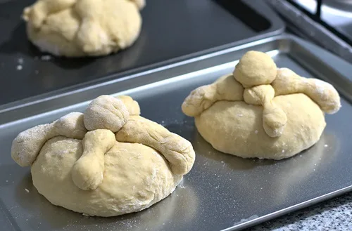 Pan de muerto antes de hornear Pan de muerto recién horneado, siendo pincelado con mantequilla y espolvoreado con azúcar.