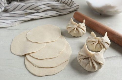 Montaje gyosas Manos realizando los pliegues tradicionales en el borde de una gyoza, asegurando el sellado perfecto del relleno.