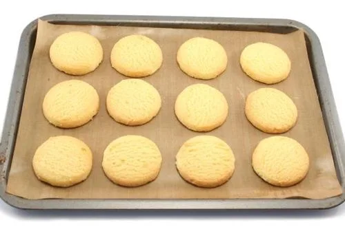 Masa de galletas de vino aplastadas en una bandeja con papel manteca, listas para hornear