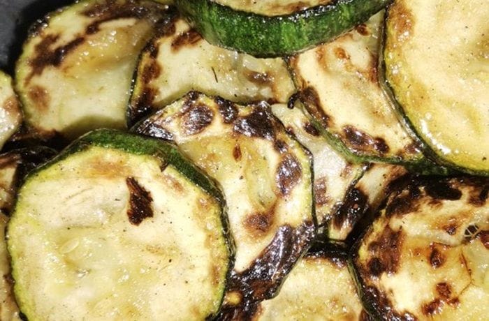 Zapallo italiano (zucchini) salteado con ajo y especias en una sartén. Acompañamiento de verduras rápido y saludable.