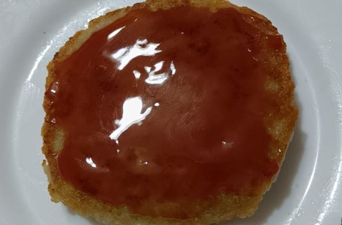 Panqueques de papa con dulce de mosqueta: Receta clásica del sur de Chile 1 Panqueque de papa chileno servido con una cucharada de dulce de rosa mosqueta en la parte superior, ideal para la once.