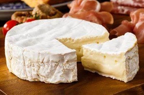 Queso Camembert Pieza de queso camembert de corteza blanca fresca antes de ser porcionada.