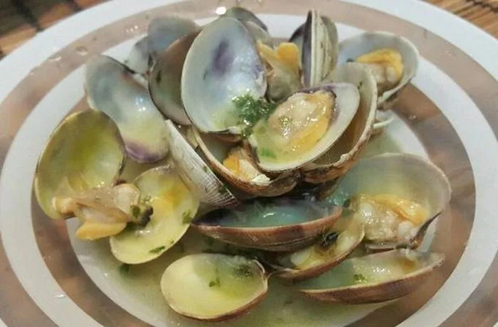 Receta de machas al vino blanco Machas al vino blanco chileno en olla, servidas con perejil