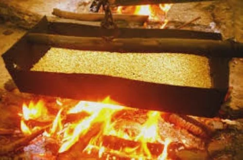 Proceso artesanal de tostado de trigo sobre una callana tradicional con fuego directo.