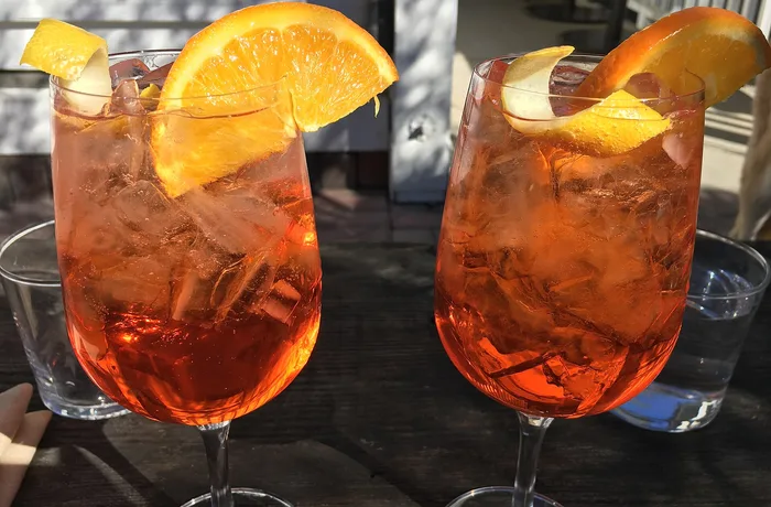 Aperol spritz Aperol spritz en copa con hielo y rodaja de naranja, receta del cóctel italiano