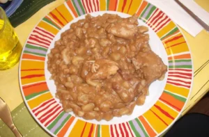 Carapulcra peruana de papa seca con cerdo servida con arroz, receta casera