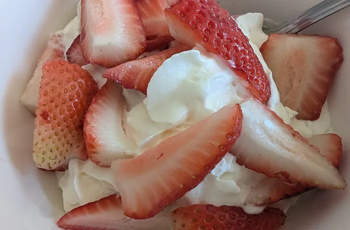 Frutillas con crema Frutillas con crema batida servidas en copa, receta chilena de temporada