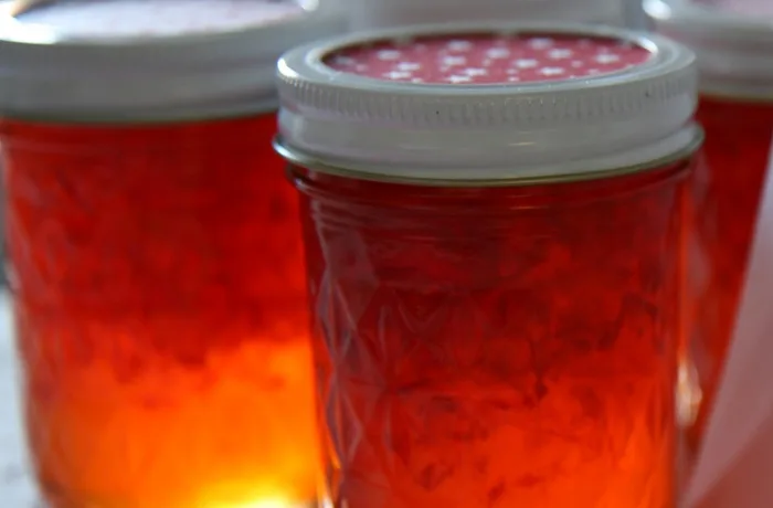 Mermelada de pimentón rojo en frasco junto a quesos, receta chilena casera