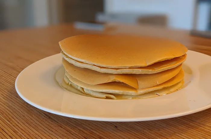 Pancakes Pila de pancakes esponjosos con miel y frutillas, receta casera de pancakes