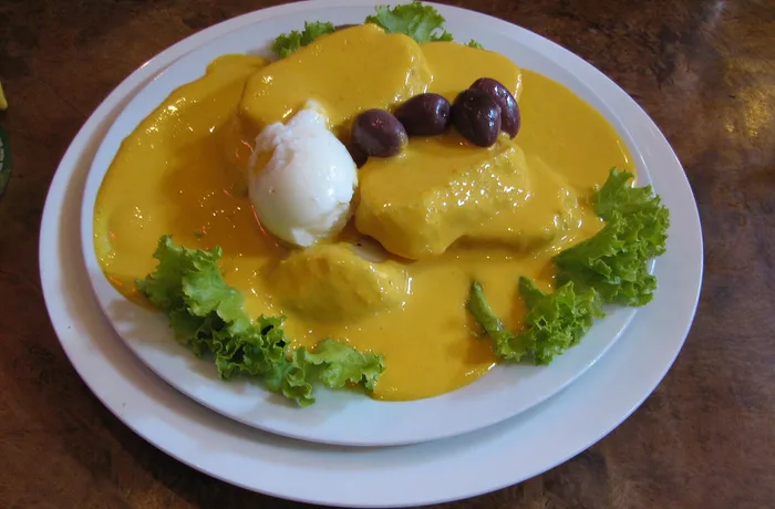 Papas a la huancaína con huevo duro, aceituna de botija y lechuga, receta peruana en la mesa chilena