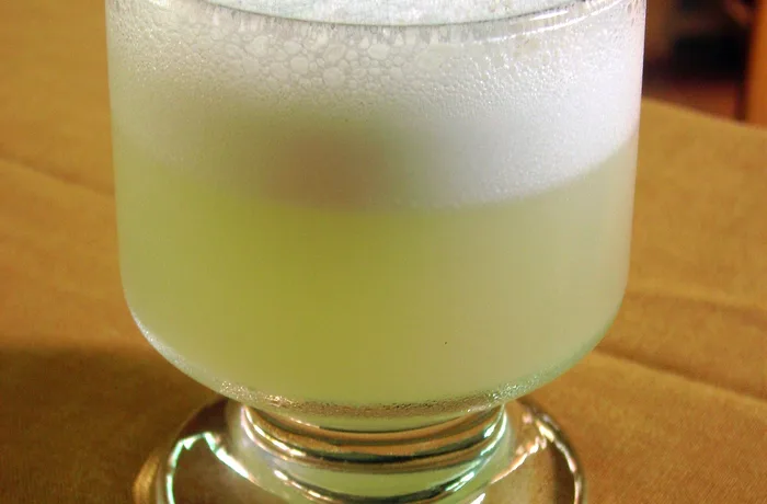 Pisco sour chileno servido en copa con espuma, receta clásica chilena